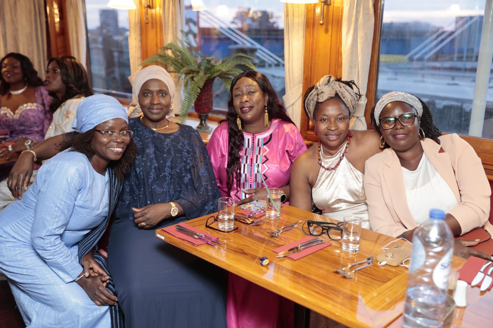 Cinq femmes de la diaspora réunies autour d'une table lors du dîner-croisière commémoratif