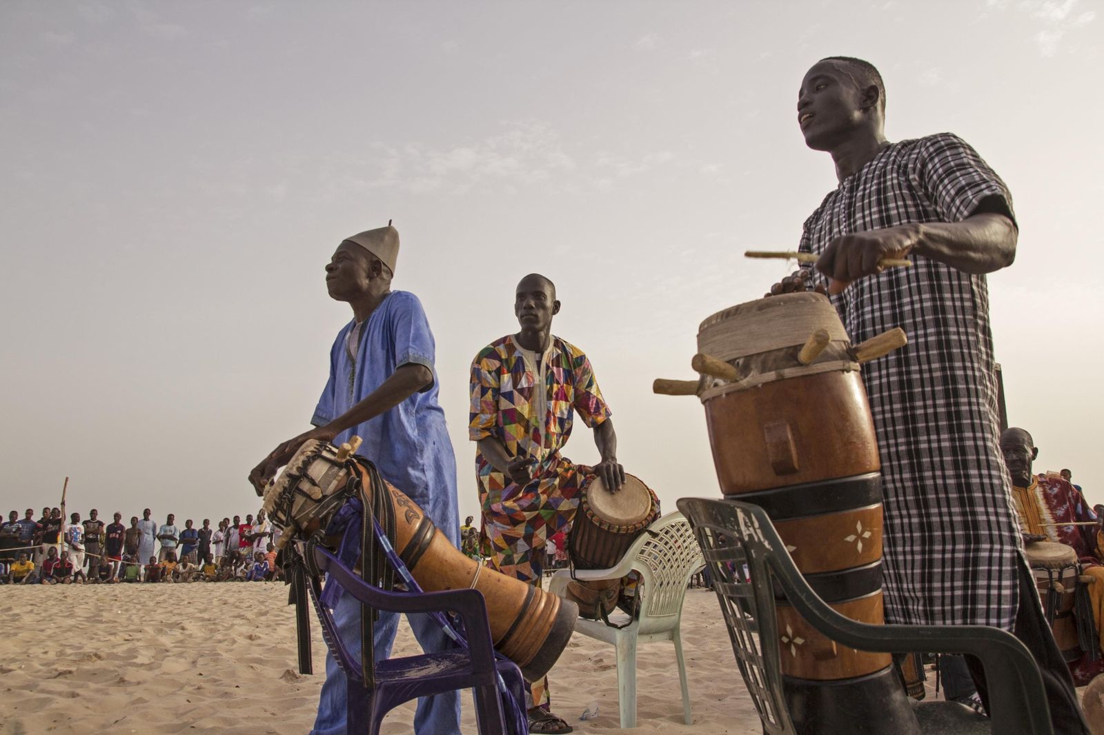 Percussionnistes jouant du tam-tam sur une plage au coucher du soleil