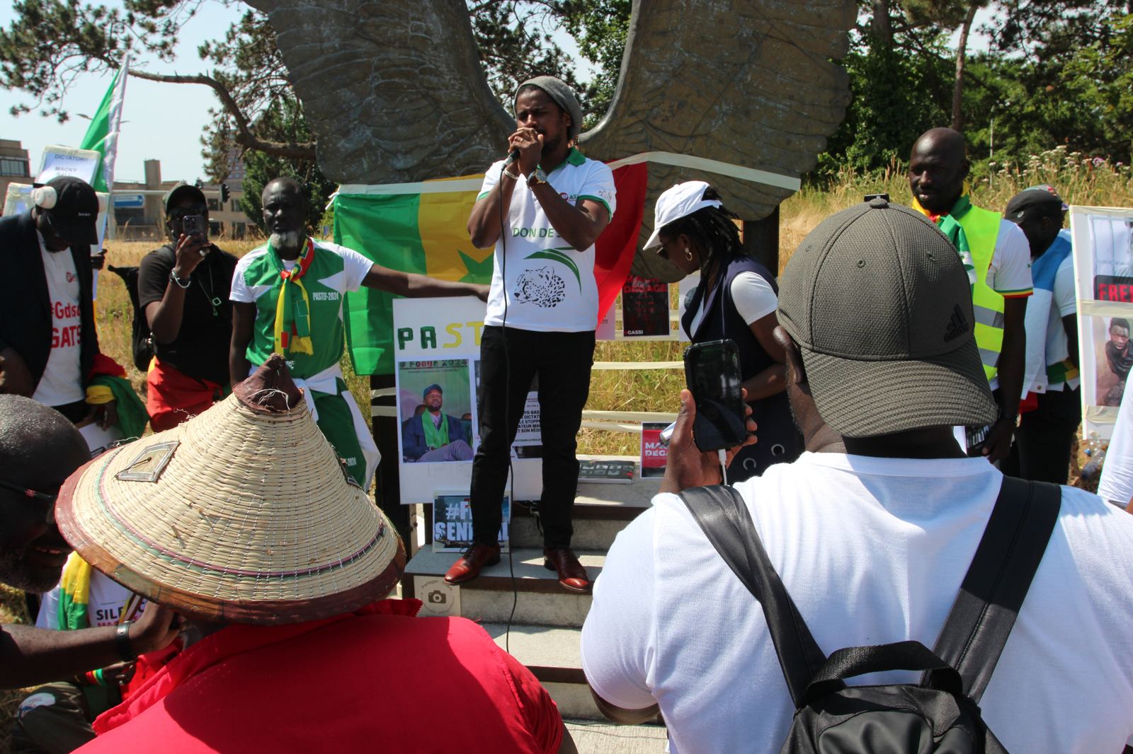 Discours de la diaspora devant le monument aux ailes près de la Cour pénale internationale
