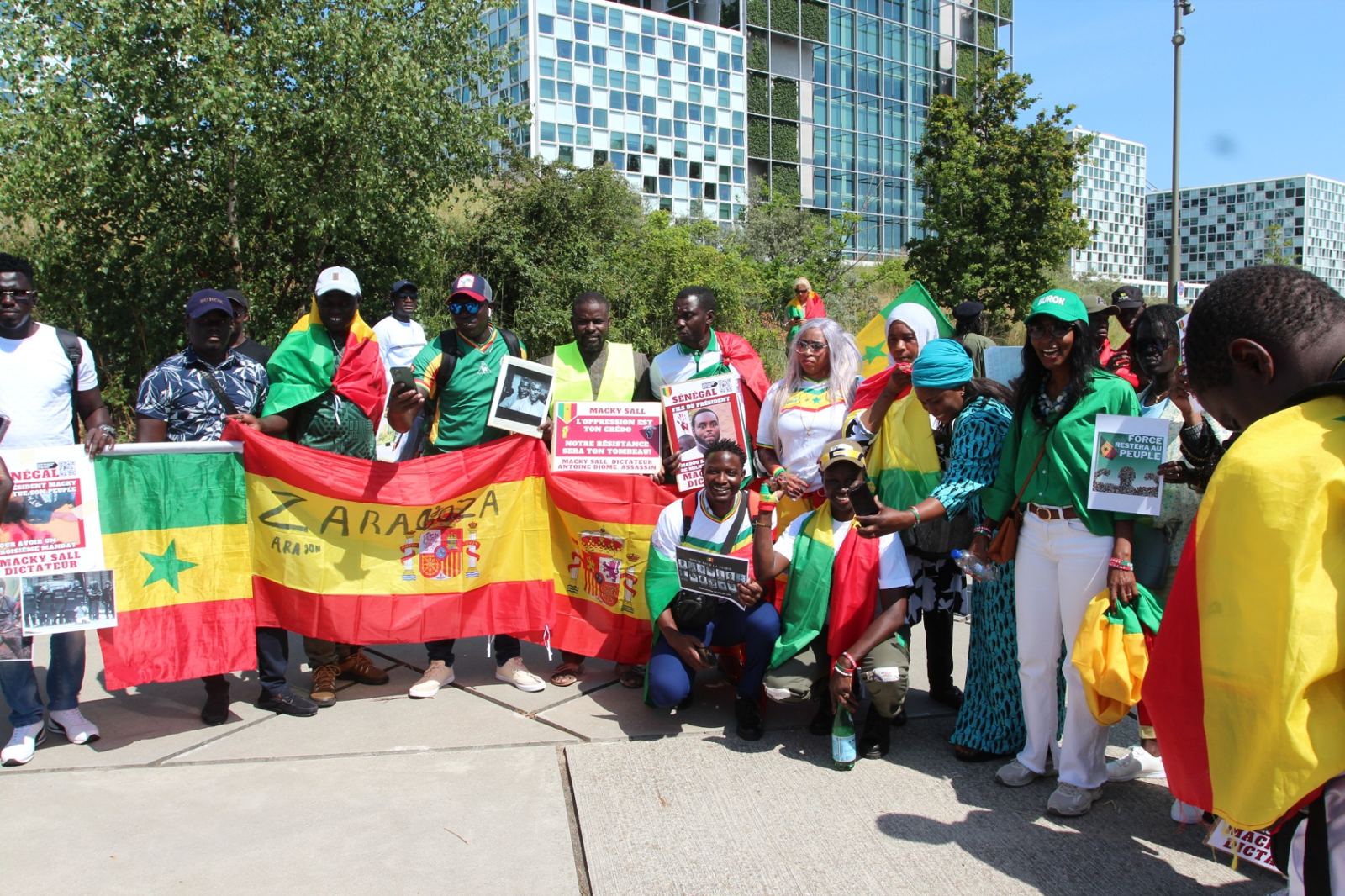 Rassemblement de la diaspora sénégalaise devant la Cour pénale internationale à La Haye avec drapeaux et banderoles