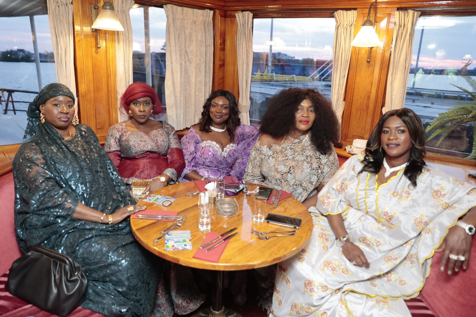 Invitées en somptueuses tenues sénégalaises posant lors de la soirée de commémoration à bord